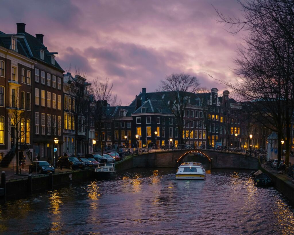 A picturesque view of Amsterdam’s canals with iconic houseboats and cycling lanes. One of Best places to visit in europe 2025