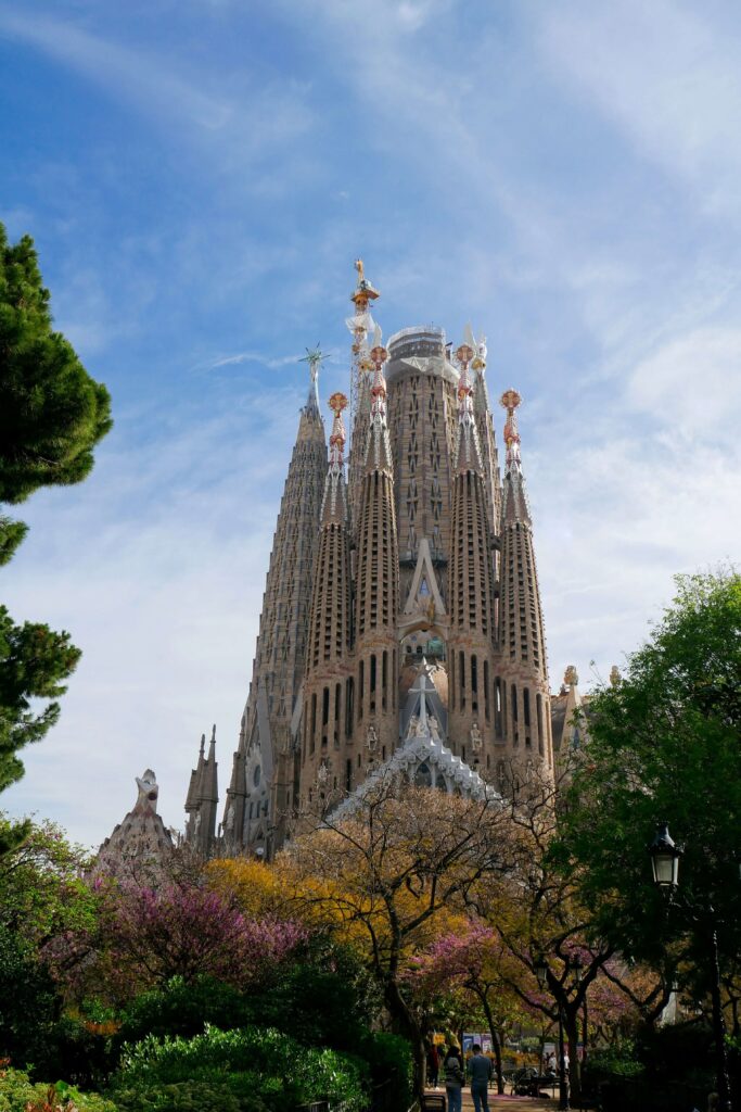 The stunning Sagrada Família with its intricate spires reaching into the blue sky in Barcelona, Spain. 